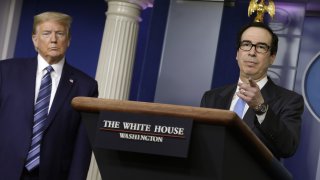 U.S. President Donald Trump, left, listens as Steven Mnuchin, U.S. Treasury secretary speaks during a news conference at the White House in Washington D.C., U.S. on Tuesday, April 21, 2020. The Trump administration vowed to stem job losses and rescue the oil industry with stimulus funds and other measures as the U.S. responds to a global glut in crude thats led to an historic rout in prices.