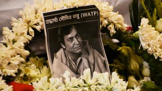 Flowers surround a photo of Indian actor Soumitra Chatterjee