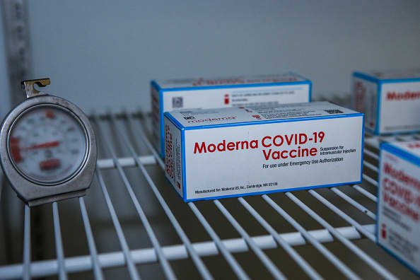 Boxes containing the Moderna COVID-19 vaccine sit in a freezer