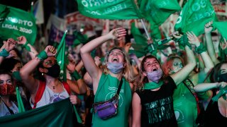 Abortion-rights activists watch live video streaming of lawmakers in session, outside Congress in Buenos Aires, Argentina, Wednesday, Dec. 30, 2020. Congress approved a bill that legalize abortion in Argentina.