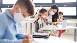 Group of children with face mask back at school after covid-19 quarantine and lockdown.