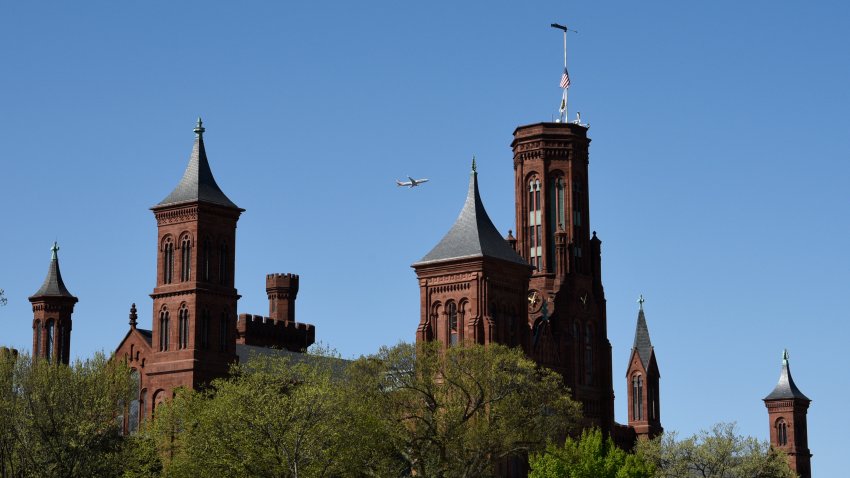 An American Airlines plane departing nearby Ronald Reagan Washington National Airport flies near the Smithsonian Institution Building on the National Mall in Washington, D.C.