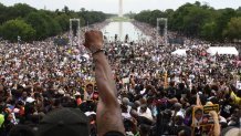 A demonstrator raises his first during the "Commitment March: Get Your Knee Off Our Necks" protest against racism and police brutality on Aug. 28, 2020, at the Lincoln Memorial in Washington, D.C. Anti-racism protesters marched on the streets of the U.S. capital after a white officer's shooting of African American Jacob Blake. The protest also marked the 57th anniversary of civil rights leader Martin Luther King's historic "I Have a Dream" speech delivered at the Lincoln Memorial.