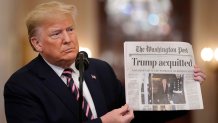 President Donald Trump holds a copy of the Washington Post as he speaks in the East Room of the White House the day after he was acquitted on two articles of impeachment by the Senate, Feb. 6, 2020, in Washington, D.C.