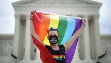 In this June 15, 2020, file photo, Joseph Fons holds a Pride flag in front of the U.S. Supreme Court building after the court ruled that LGBTQ people can not be disciplined or fired based on their sexual orientation in Washington, D.C.