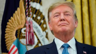 US President Donald Trump looks on after presenting the Presidential Medal of Freedom to Celtics basketball legend Bob Cousy in the Oval Office of the White House in Washington, DC on August 22, 2019.