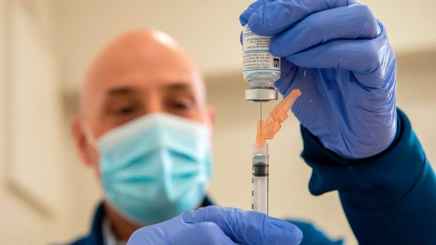 Pharmacist Jason Hyde fills syringes with the Moderna COVID-19 vaccine as first responders wait to receive it at UMass Memorial Hospital in Marlborough, Massachusetts, on January 12, 2021.