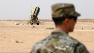 A member of the U.S. Air Force stands near a Patriot missile battery at the Prince Sultan air base in al-Kharj