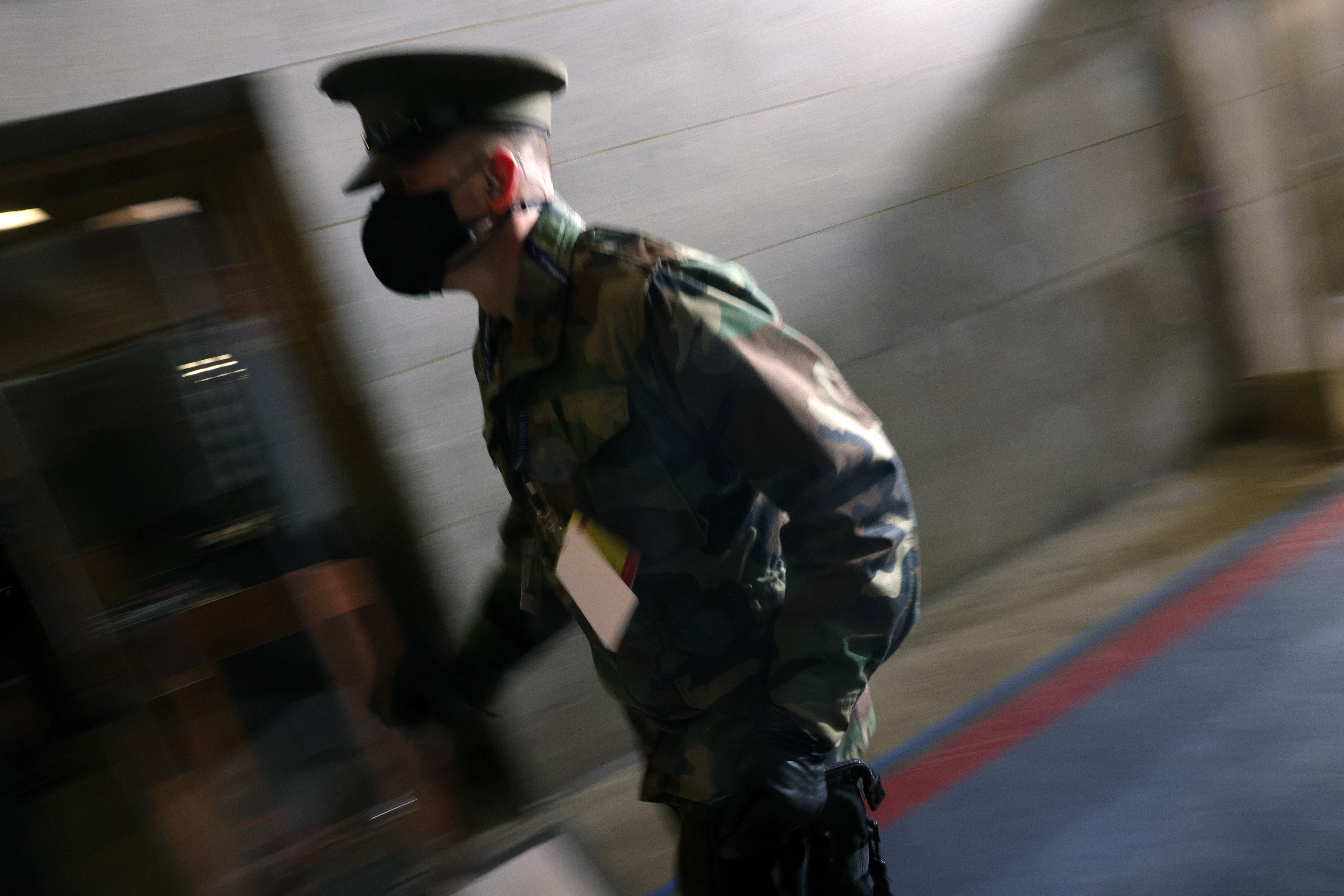 WASHINGTON, DC – JANUARY 18: A member of the military rushes past as people are evacuated back inside after an “external security threat” prior to a dress rehearsal for the 59th inaugural ceremony for President-elect Joe Biden and Vice President-elect Kamala Harris at the U.S. Capitol on January 18, 2021 in Washington, DC. Biden will be sworn-in as the 46th president on January 20th.  (Photo by Win McNamee/Getty Images)