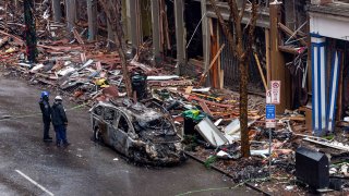 Oficiales inspeccionan los destrozos dejados por un ataque de coche bomba en el centro de Nashville.