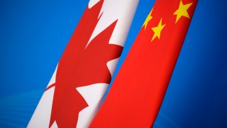 In this Nov. 12, 2018, file photo, flags of Canada and China are placed for the first China-Canada economic and financial strategy dialogue in Beijing, China. China says it has lodged a formal complaint with Canada over T-shirts ordered by one of the country’s Beijing Embassy staff that allegedly mocked China’s response to the coronavirus outbreak.