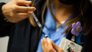 In this Feb. 16, 2021, file photo, RN Rusha Prajapati reconstitutes the Pfizer-BioNTech COVID-19 vaccine at La Colaborativa in Chelsea, Massachusetts.