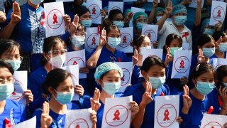 Teachers from the Yangon Education University hold signs in Yangon, Myanmar, on Friday, Feb. 5, 2021. A senior member of Myanmar's deposed ruling party has become the latest prominent politician arrested as the country's new military government confronts continuing resistance to its seizure of power. The signs read "Civil Disobedience Myanmar Teachers."