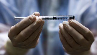 In this Dec. 15, 2020, file photo, Rocky Mountain Regional VA Medical Center investigational pharmacy technician Sara Berech holds a dose of the Johnson & Johnson COVID-19 vaccine before it is administered in a clinical trial in Aurora, Colorado.