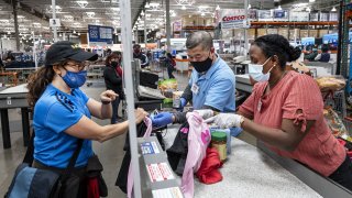 A shopper wearing a protective mask checks out at a Costco store