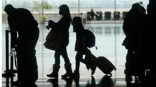 Travelers walk through the Salt Lake City International Airport Wednesday, March 17, 2021, in Salt Lake City. Airlines and others in the travel industry are throwing their support behind vaccine passports to boost pandemic-depressed travel, and authorities in Europe could embrace the idea quickly enough for the peak summer vacation season.