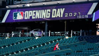 A worker cleans seats to prepare Coors Field for the return of fans in the era of the coronavirus during a news conference Wednesday, March 31, 2021, at the stadium in downtown Denver. A small number of fans were allowed to watch the Rockies go through a workout Wednesday before the team hosts the Los Angeles Dodgers in the squads' season-opener Thursday, April 1.