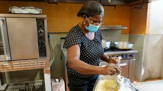 Doramise Moreau covers shredded malanga that will be served with baked fish to those that need a meal at Notre Dame d'Haiti Catholic Church, March 8, 2021, in Miami.