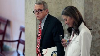 In this March 26, 2020, file photo Ohio Gov. Mike DeWine, left, and Dr. Amy Acton, director of the Ohio Department of Health, leave the State Room before their daily update on the states response to the ongoing COVID-19 pandemic at the Ohio Statehouse in Columbus, Ohio. After months of repeated requests, Dewine has released only three documents the AP asked to see.