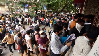People wait in queues outside the office of the Chemists Association to demand necessary supply of the anti-viral drug Remdesivir, in Pune, India