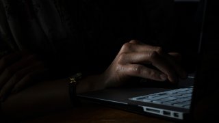 hand on laptop dark generic