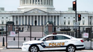In this April 28, 2021, file photo, a U.S. Capitol Police patrol car drives past the fence perimeter on the east side of the U.S. Capitol before President Joe Biden delivers his address to the joint session of Congress.