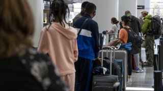 Travelers wait to check in to a flight inside the international terminal at San Francisco International Airport (SFO) in San Francisco, California, on Tuesday, May 11, 2021.