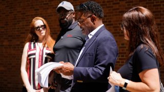 From left, Brooke Vaughn, her husband former NFL player Clarence Vaughn III, former NFL player Ken Jenkins and his wife Amy Lewis read a letter before delivering tens of thousands of petitions demanding equal treatment for everyone involved in the settlement of concussion claims against the NFL, to the federal courthouse in Philadelphia, Friday, May 14, 2021.