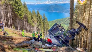 In this May 23, 2021, file photo, rescuers work by the wreckage of a cable car after it collapsed near the summit of the Stresa-Mottarone line in the Piedmont region, northern Italy. A mountaintop cable car plunged to the ground in northern Italy on Sunday, killing 14 people.