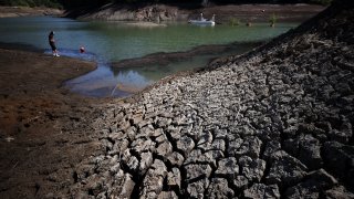 Dry cracked earth is visible along the banks of Phoenix Lake on April 21, 2021 in Ross, California.