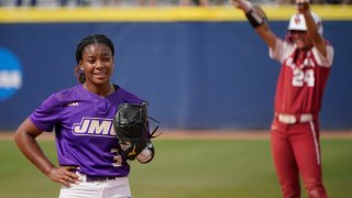 James Madison starting pitcher Odicci Alexander (3) stands in the pitching circle as Oklahoma's Jayda Coleman (24) celebrates at second base behind her