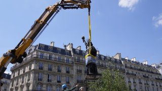 Workers secure the move of the "Liberty Enlightening the World" by Frederic Auguste Bartholdi, a mini-replica of the French-designed Statue of Liberty
