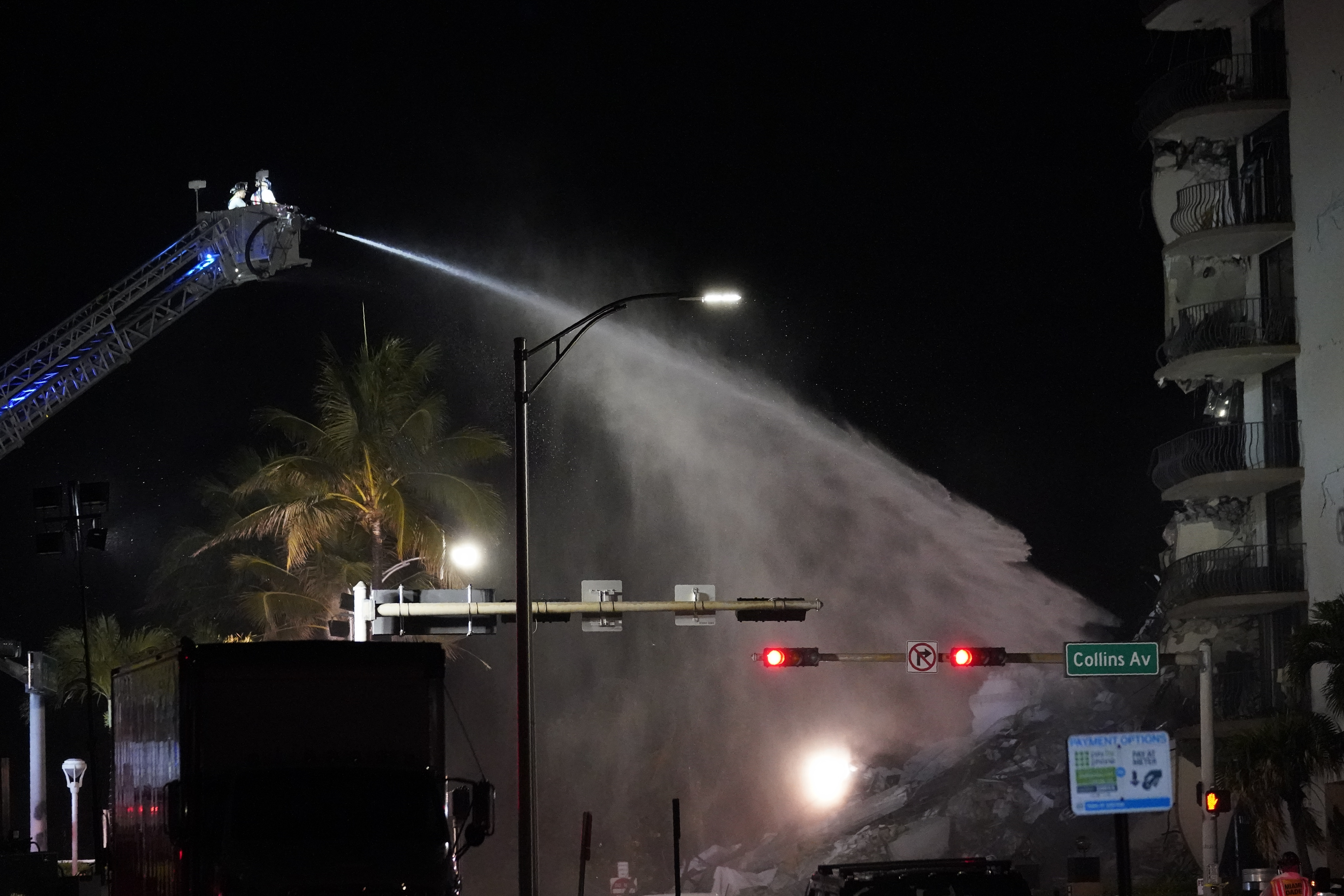 A Miami-Dade Fire Rescue team sprays water onto the rubble as rescue efforts continue where a wing of a 12-story beachfront condo building collapsed, late on Thursday, June 24, 2021, in the Surfside area of Miami.