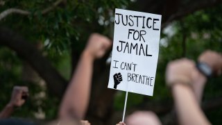 CHARLESTON, SC - MAY 17: Protestors raise their fists, calling for justice for Jamal Sutherland at Marion Square on May 17, 2021 in Charleston, South Carolina. Sutherland, a black man suffering from mental illness, died after Charleston County deputies shocked him with a stun gun when removing him from a jail cell. Activists want charges brought against the deputies.