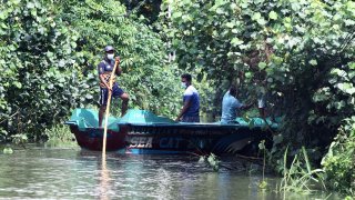 People row a boat to distribute food to flood-trapped villagers on the outskirts of Colombo, Sri Lanka, on June 5, 2021. The death toll from Sri Lanka's inclement weather conditions rose to 10 Saturday evening while 219,027 people were affected, the country's Disaster Management Center said.