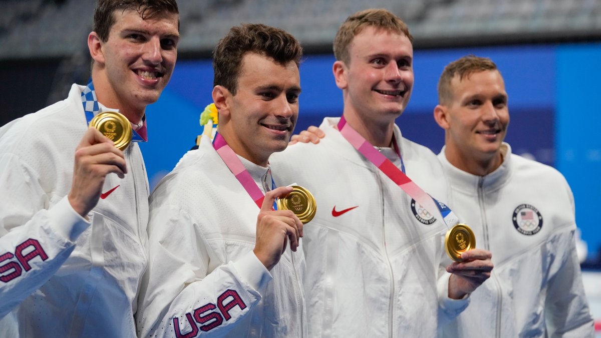 Caeleb Dressel throws his gold medal in the stands to Brooks Curry ...