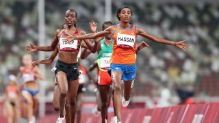 Sifan Hassan of Team Netherlands crosses the finish line first ahead of Agnes Jebet Tirop of Team Kenya in Heat 1 of the Women's 5000m Round 1