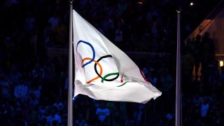 The Olympic flag atop a flag pole