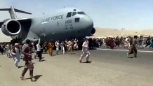 Hundreds of people run alongside a U.S. Air Force C-17 cargo plane trying to take off at Kabul International Airport, Kabul, Afghanistan, Aug. 16, 2021.