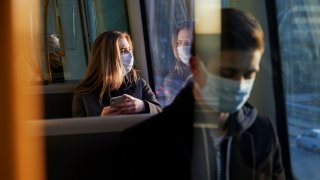 commuters wearing masks aboard public transportation