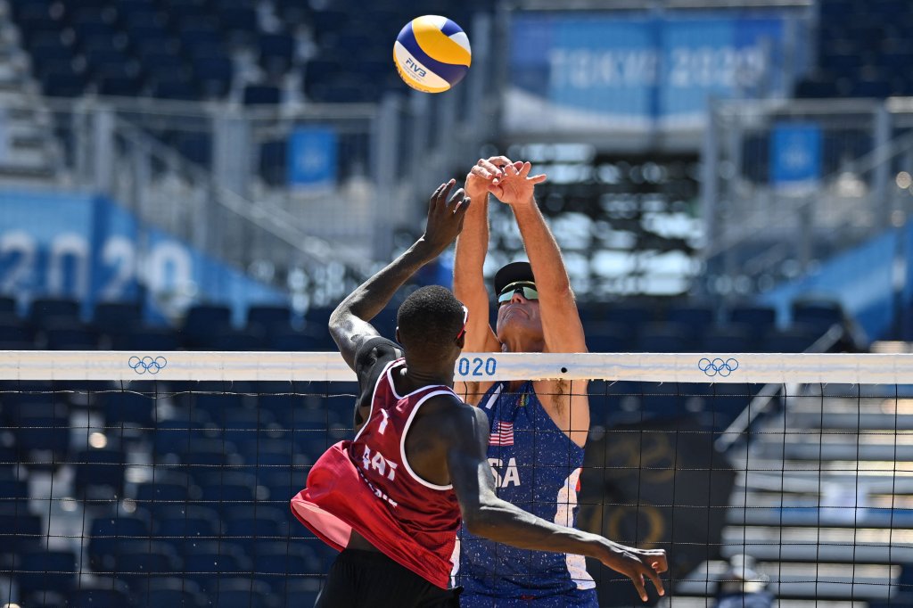 Qatar's Cherif Younousse (L) attempts a shot past USA's Philip Dalhausser in their men's beach volleyball round of 16 match between Qatar and the USA during the Tokyo 2020 Olympic Games at Shiokaze Park in Tokyo on August 1, 2021.