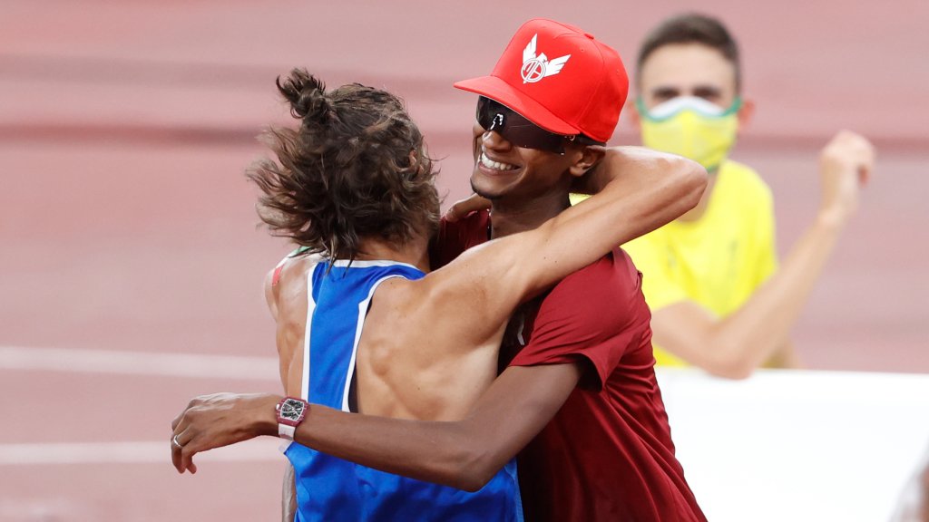 Mutaz Essa Barshim of Qatar and Gianmarco Tamberi of Italy hug, Aug. 1, 2021. The two have decided to share first place golds in high jump.