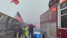 Fairfax firefighters and onlookers saluted the procession for a fallen soldier as the storm moved through Annandale.