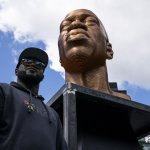 Terrence Floyd stands beside a sculpture of his brother George Floyd