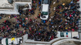 Migrants crowd into the patio at the Attorney Generals office after they were intercepted from inside cargo trailer trucks driving on the highway, in Coatzacoalcos, Veracruz state, Mexico, Friday, Nov. 19, 2021. About 500 migrants were riding in two cargo trucks when they were stopped and detained by the Criminal Investigation Agency and the National Immigration Institute, according to those two organizations.