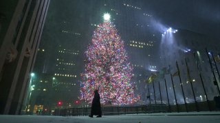 A man walks by the 2020 Rockefeller Center Christmas Tree