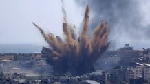 A blast from an Israeli airstrike on a building in Gaza City throws dust and debris on May 13, 2021, as Hamas and Israel traded more rockets and airstrikes and Jewish-Arab violence raged across Israel at the end of the Muslim holy month of Ramadan.