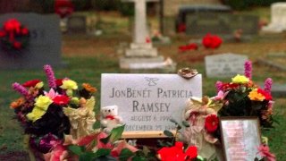 FILE - Flowers, pictures and stuffed animals adorn the gravesite of JonBenet Patricia Ramsey on Dec. 26, 1997, at the St. James Episcopal Church Cemetery in Marietta, Ga. Twenty-five years after JonBenet Ramsey was killed, police say DNA hasn’t been ruled out to help solve the case. The 6-year-old was found dead in the basement of her family’s Boulder, Colo., home on Dec. 26, 1996. Her death was ruled a homicide, but nobody was ever charged in the case.
