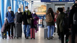 Travelers walk through Terminal 1 at O'Hare International Airport in Chicago, Thursday, Dec. 30, 2021.