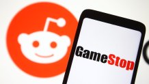 A GameStop logo seen in front of Reddit logo. A Reddit community turned Wall Street upside down in January when users of r/WallStreetBets created a short squeeze with the gaming retailer's stocks.